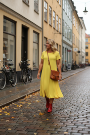 Gul Ballerina-klänning vid äldre stadsfasad