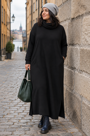 Svart poloklänning vid stenmur