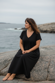Svart — sittande på klippa, blickar ut