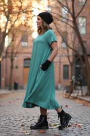Turkos klänning med svart mössa i sidovinkel